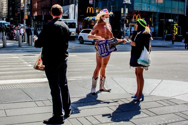 A photo of the Naked Cowboy wearing a mask in Times Square